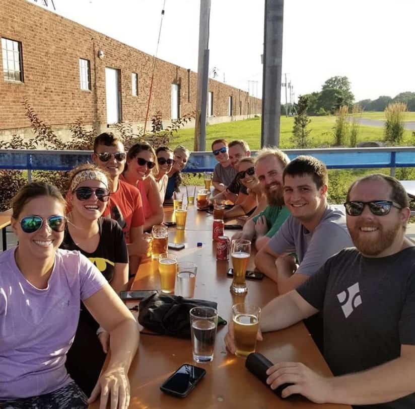 Blue Compass team members drinking beer together.