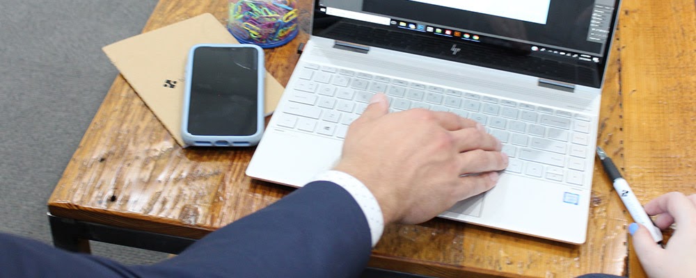 a man's hand using a laptop computer
